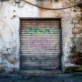 Poco pi� avanti ecco altre sei saracinesche abbassate e prese di mira dai writers